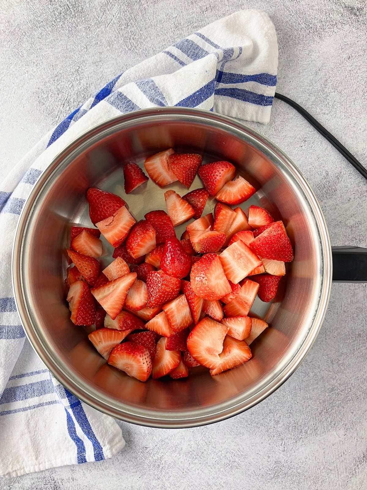 Sliced strawberries in a saucepan.