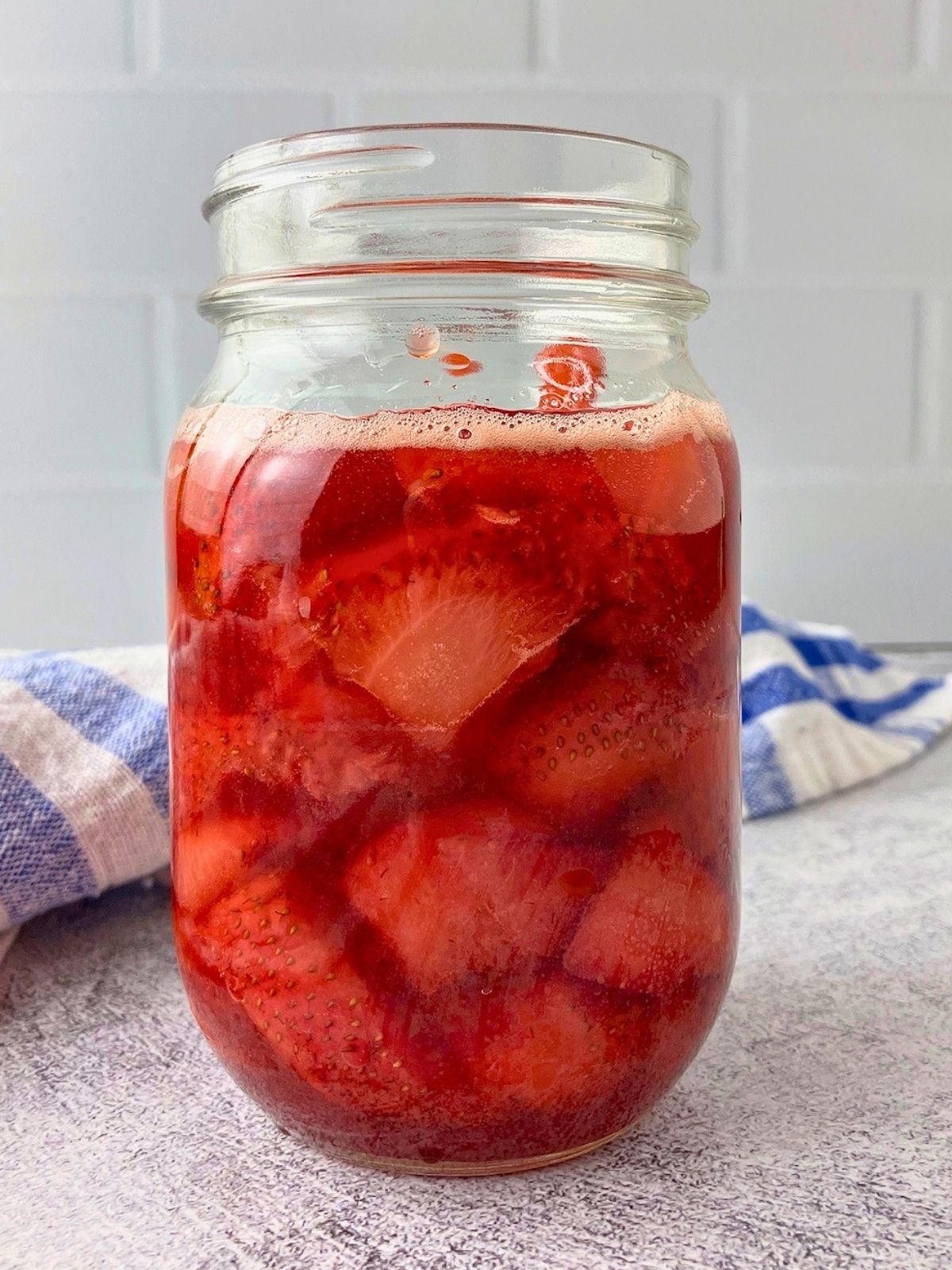 A glass jar filled with homemade strawberry compote.