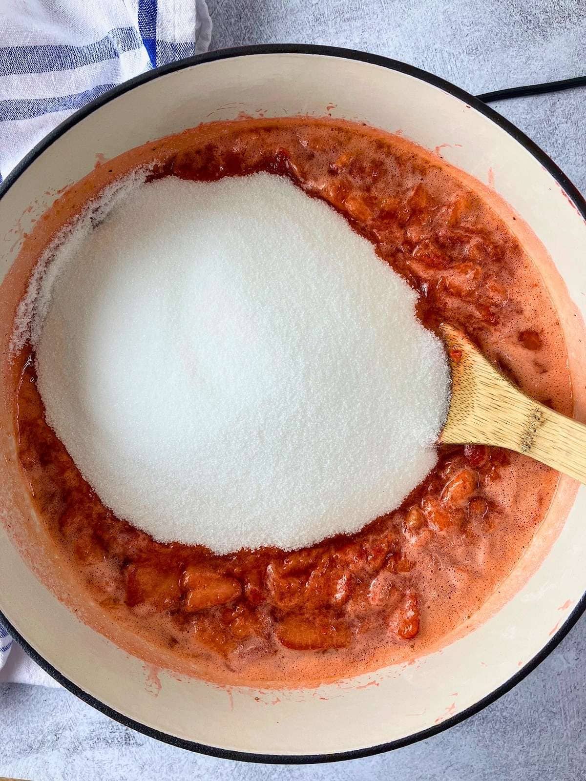 The sugar was poured into the cooked strawberry mixture.