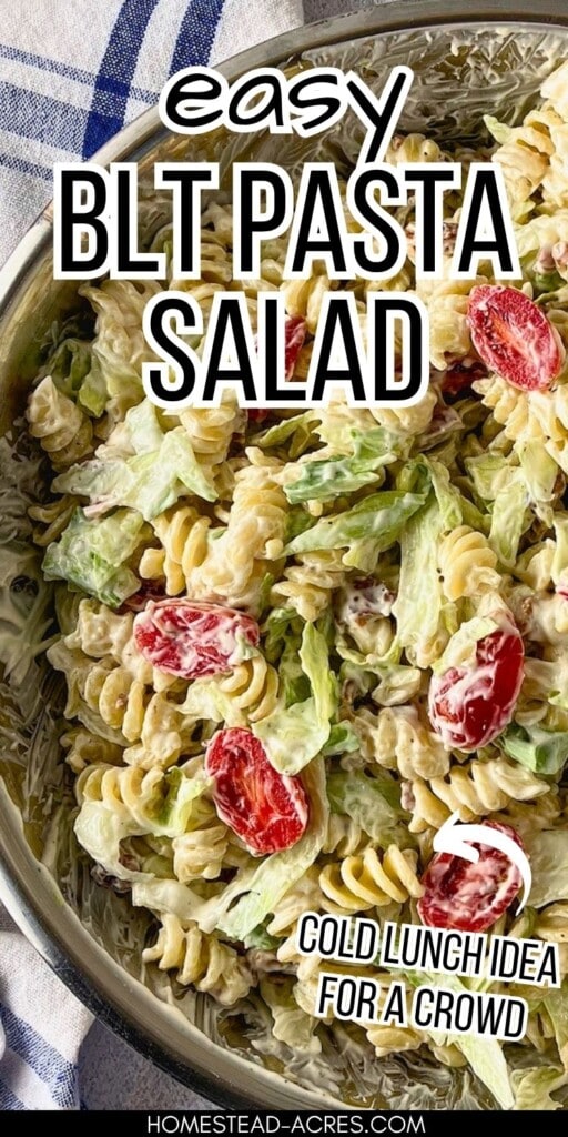 Close-up of a creamy BLT pasta salad with rotini pasta, lettuce, and grape tomatoes in a metal bowl. The text says: "Easy BLT Pasta Salad Cold Lunch Idea For A Crowd."