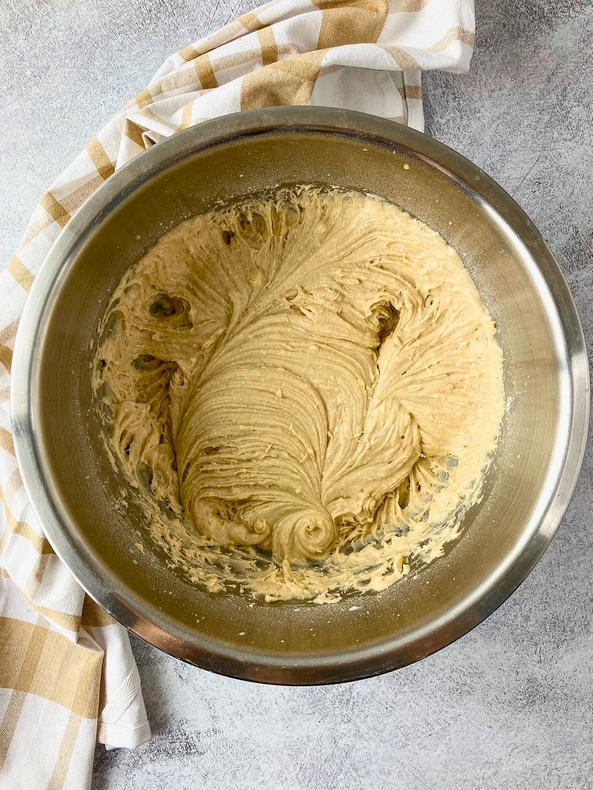 Smooth blueberry cobbler batter in a stainless steel mixing bowl.