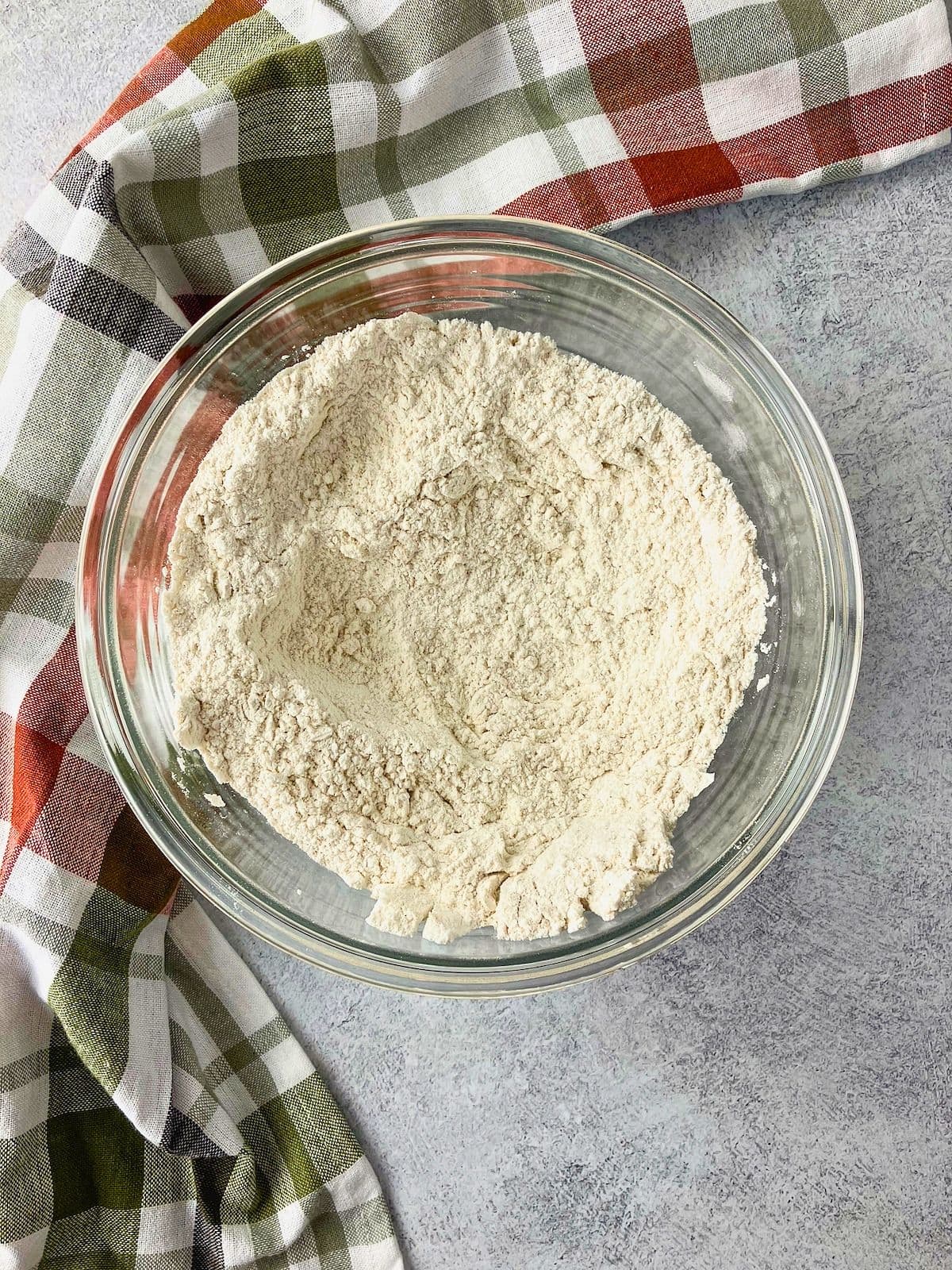 Overhead view of a clear glass bowl filled with the mixed dry ingredients.